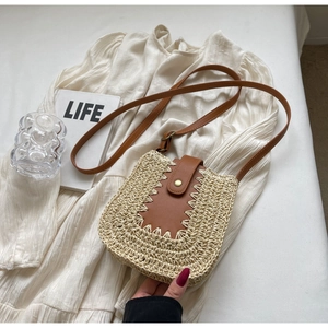 Détail d'un sac en paille tressée avec bordure en cuir festonné et bouton rétro chic