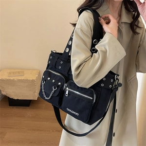 Sac fourre-tout punk en toile noire avec rivets et chaîne porté par un modèle
