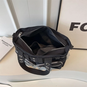 Sac fourre-tout en toile noire avec rivets et poches multiples vu sous un angle de 45 degrés