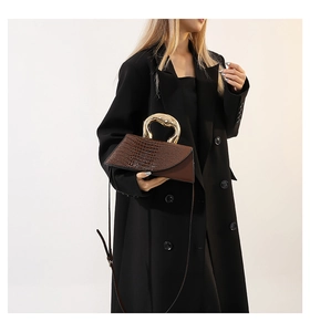 Détail du sac marron à motif crocodile avec poignée en métal doré liquide unique