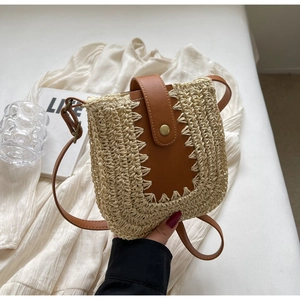 Détail du sac bandoulière en paille tissé main avec lanière et boucle en cuir brun