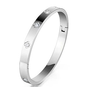 Macro detail of silver titanium steel bangle featuring floral patterns and zircon stones