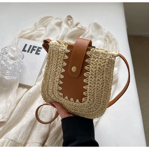 Détail du sac bandoulière en paille avec panneau en cuir marron et coutures faites main