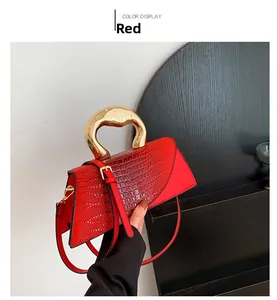 Détail du sac à main rouge motif crocodile avec poignée en métal doré unique