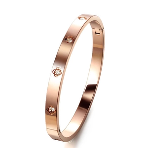 Detail of rose gold titanium steel bangle with floral zircons and brushed metal finish