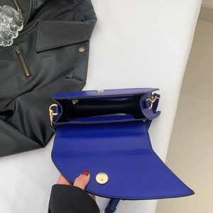 Détail du sac selle bleu marine ouvert avec fermoir doré et poche intérieure zippée