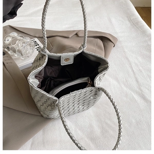 Detailed macro view of silver woven tote bag with brown lining and magnetic closure