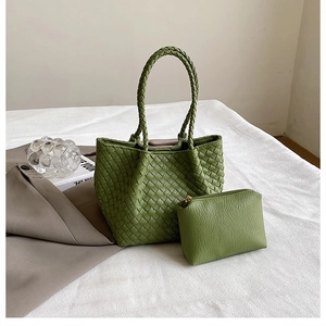 Detail of woven green leather tote set with matching lychee pattern pouch on white fabric