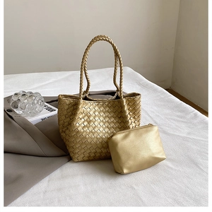 Detailed close-up of golden woven texture on luxury tote bag with matching inner pouch
