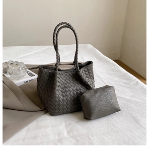 Detailed view of dark grey woven tote bag with matching zippered pouch and twin handles