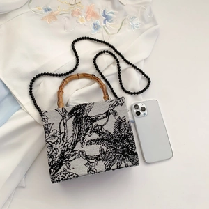 Elegant embroidery handbag with bamboo handle and black bead chain in classic toile pattern