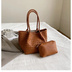 Detail of a brown woven tote bag set featuring premium leather texture and a matching pouch