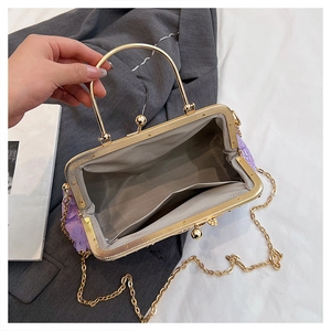 Detail of purple floral evening bag showing jacquard petals and inner lining