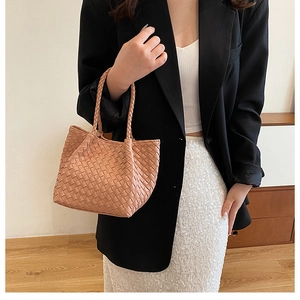 Detail of woven faux leather texture and carry handle on a French style handbag