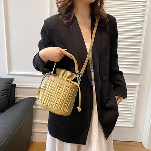 Pale yellow woven bucket bag with leather drawstring and detachable crossbody strap
