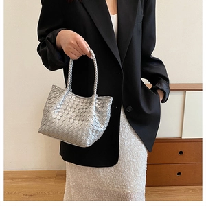 Detail of silver metallic woven tote bag featuring a high-quality leather intrecciato texture