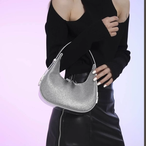 Sparkly silver sequin moon bag with adjustable handle shown on a stylish model