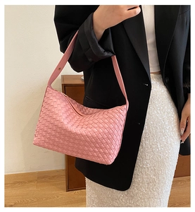 Close-up of pink woven hobo bag on shoulder highlighting the leather texture and craftsmanship