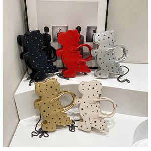 Detailed view of dinosaur-shaped handbags with metallic rivets and chain straps in five colors