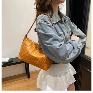Detail of caramel woven leather shoulder bag showing intricate texture and modern design