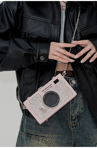 Dettaglio della borsa a tracolla rosa a forma di macchina fotografica con strass