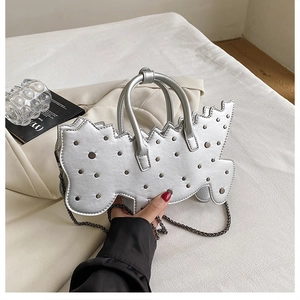 Close-up of silver irregular tote with metallic studs and polished chain strap detail