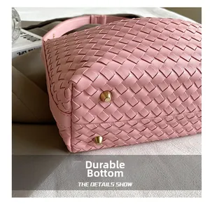 Macro detail of pink woven handbag base with gold feet for wear resistance