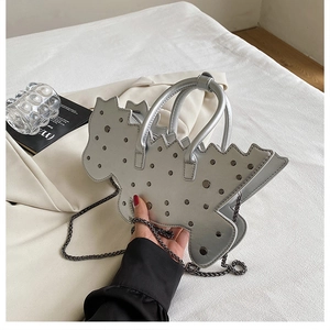 Detail view of silver butterfly-shaped handbag with metallic studs and chain strap
