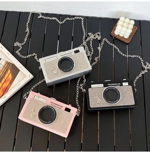 Dettaglio delle borse a tracolla a forma di fotocamera con strass in rosa, argento e nero