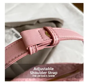 Detail of adjustable pink shoulder strap with gold buckle on woven crossbody bag