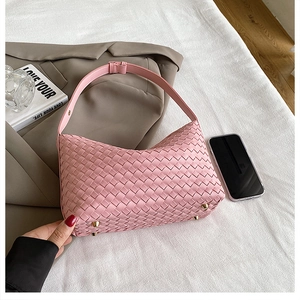 Macro shot of pink woven hobo bag showing bottom gold feet and soft synthetic leather
