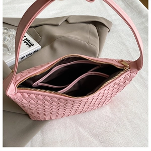 Detail of pink woven shoulder bag showing interior lining and gold zipper closure