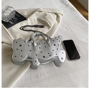 Detail of silver dinosaur handbag with metallic rivets and stylish chain strap