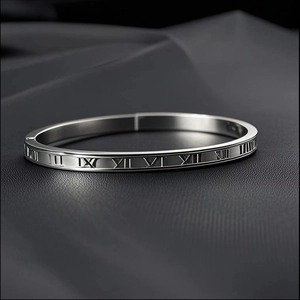 Polished silver stainless steel bangle featuring engraved Roman numerals on grey leather