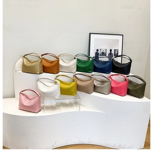 Detailed view of colorful woven handbags arranged neatly on tiered white display stands