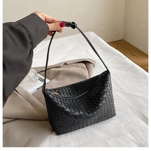 Close-up of black woven leather hobo bag with adjustable strap and intricate texture