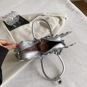 Top view of silver dinosaur shaped bag showing interior lining and zipper detail