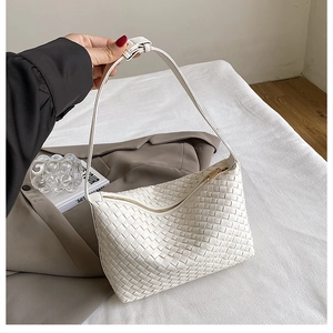 Detail of white woven texture hobo bag with adjustable strap and metal zipper closure