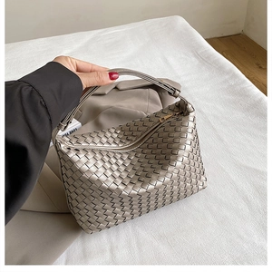 Close-up of champagne silver woven leather texture and premium gold metal zipper detail