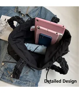 Macro view of black nylon tote bag showing spacious interior with tablet and umbrella