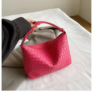 Macro view of magenta woven hobo bag detailing Intrecciato craft and premium texture