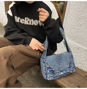 Detailed view of vintage washed denim hobo bag featuring pocket details and rivets