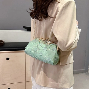 Mint green floral jacquard handbag with gold frame and chain strap on neutral background