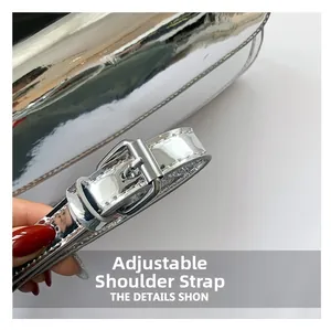Macro detail of silver patent leather bag featuring an adjustable shoulder strap with metal buckle