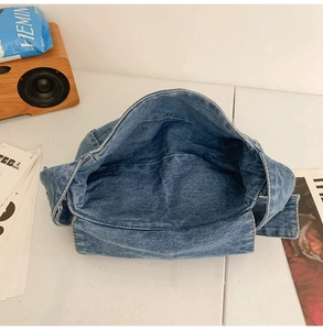Detail view of the spacious inner compartment of the vintage blue denim flap crossbody bag