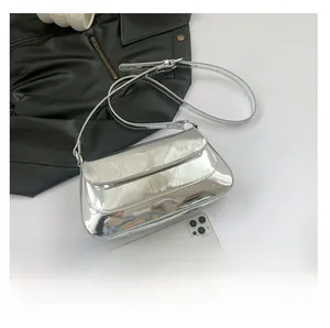 Silver patent leather baguette bag shown with smartphone to demonstrate capacity