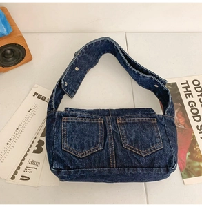Detail of dark blue denim tote with ginger contrast stitching and double front pockets