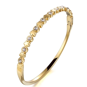 Detail of gold-plated clover bracelet featuring inlaid clear zircons and snap closure
