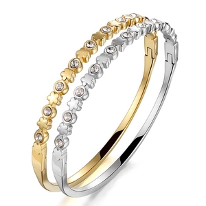 Gold and silver heart clover bracelets with zircons on a white background