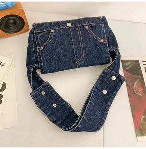Detail of blue denim crossbody bag featuring vintage jeans waist design and metal buttons